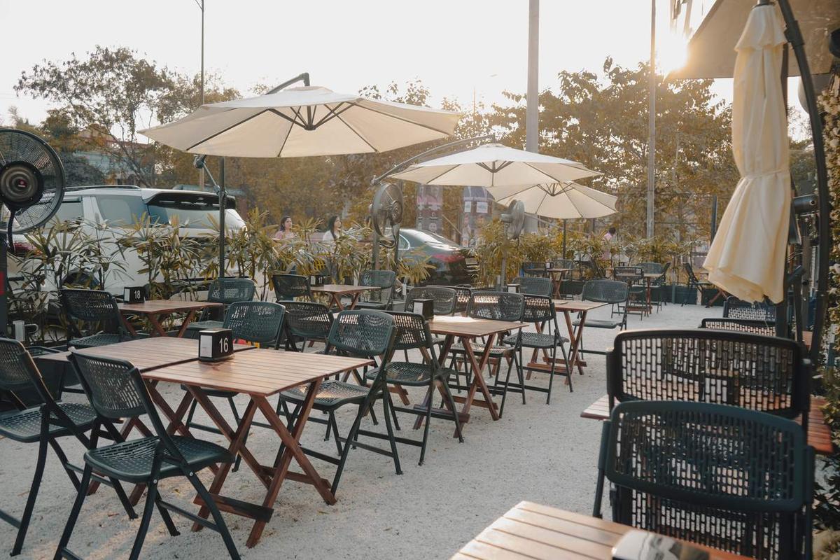 Outdoor seating with umbrellas at a TAN Coffee outlet